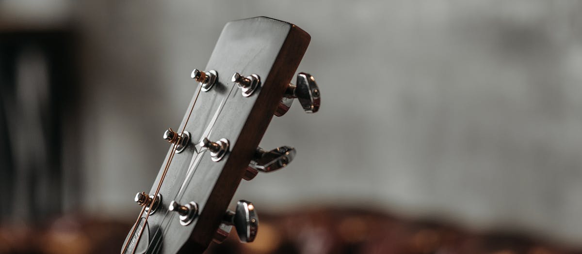 Detailed image of an acoustic guitar headstock with tuning pegs in focus.